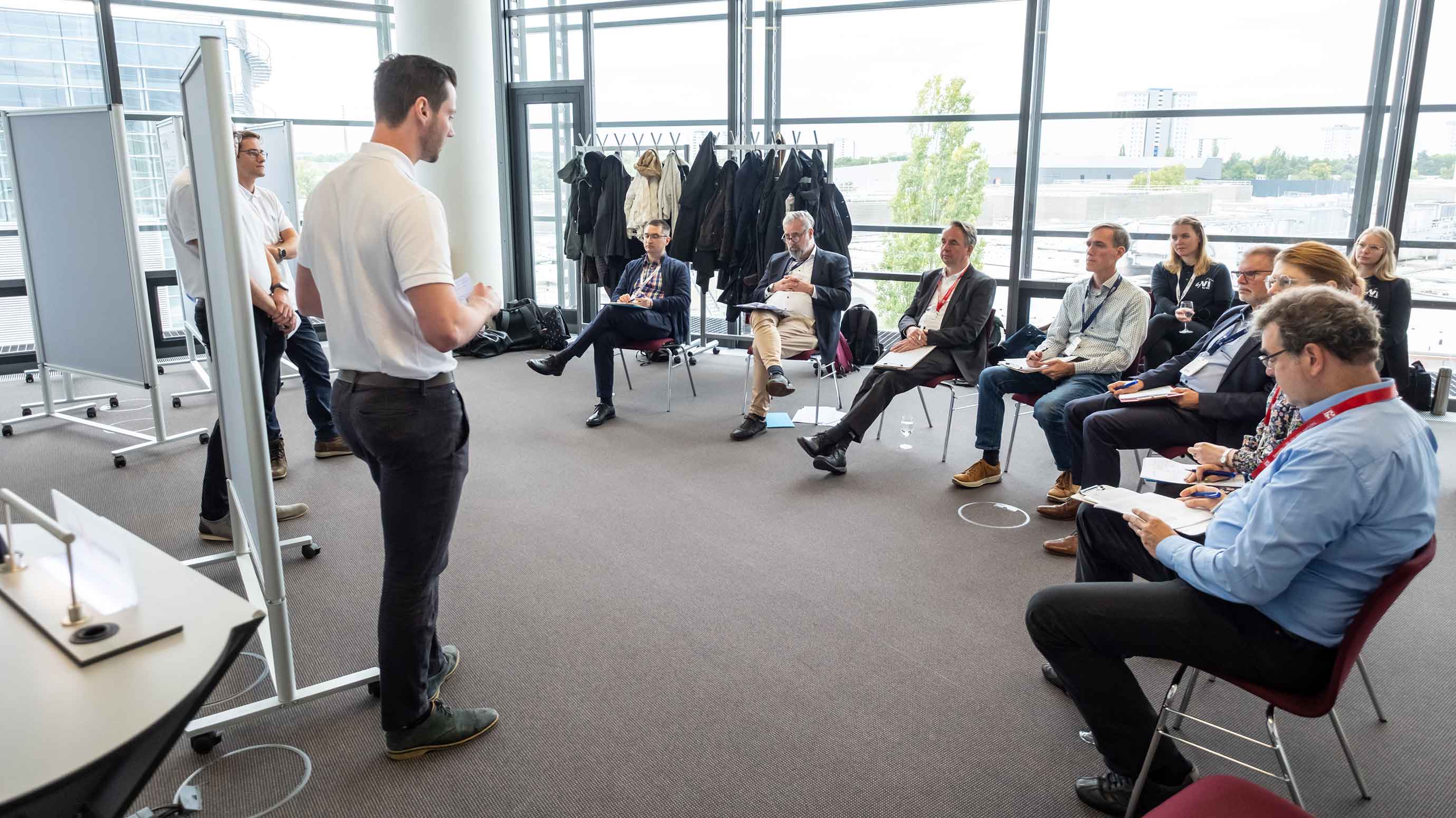 Group discussion in a modern conference room, one person presenting at a whiteboard.